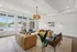 Elegant living room with contemporary furniture, large windows overlooking a pool, and stylish ceiling lighting.