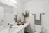 Bright and modern bathroom featuring elegant decor, sleek fixtures, and a stylish vanity with a large mirror.