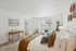 Bright and inviting bedroom with elegant decor, featuring a cozy bed, stylish desk, and large window providing natural light.