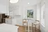 Bright, modern kitchen with sleek white cabinetry, stainless steel appliances, and a cozy breakfast nook with a charming garden view.