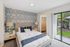 Inviting bedroom with chic patterned wallpaper, plush bedding, and a spacious walk-in closet, opening to a serene outdoor view.