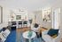 Contemporary open-concept living space featuring a modern kitchen with bar seating, a cozy living room with stylish decor, and elegant lighting.