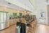 Contemporary kitchen featuring floral backsplash, sleek stainless steel appliances, and a stylish island with chic pendant lighting.
