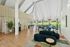 Bright, open-concept lobby with a high vaulted ceiling, modern seating, and panoramic garden views.