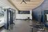 Modern fitness center with state-of-the-art equipment and sleek design, featuring a spacious gym area overlooking a pool.