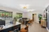 Modern and inviting office space with stylish lighting, large windows, and elegant furnishings, surrounded by lush greenery.