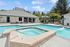 Inviting outdoor pool area with a spacious sundeck, surrounded by lush greenery and modern amenities.