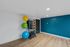 Modern fitness room with vibrant exercise balls, yoga mats, and training equipment on sleek wooden flooring.