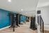 Modern apartment gym featuring a sleek weight rack, multifunctional fitness equipment, and mirrored walls for an inspiring workout.
