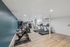 Modern fitness center with treadmills, exercise bike, and weights on wood flooring in a well-lit space.
