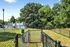 Charming outdoor pet-friendly area with secure fencing, nestled amidst lush green trees, perfect for pet owners seeking convenience and nature.