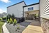 Inviting leasing office exterior with modern siding, elegant stone accents, and lush landscaping at Renew Watford.