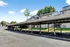 Sunny apartment complex with covered parking, surrounded by lush greenery, offering a perfect blend of comfort and convenience.