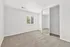 Bright, spacious bedroom with plush carpet and mirrored closet doors, bathed in natural light from a large window.