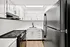 Modern kitchen featuring sleek black appliances, pristine white cabinetry, and a stylish black faucet, offering a bright and inviting culinary space.