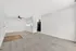 Chic open-concept apartment with elegant carpet flooring, modern ceiling fan, and sleek kitchen with stylish black appliances.