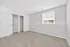 Bright bedroom with large window, fresh carpeting, and spacious closets offering ample storage.