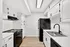 Sleek modern kitchen with white cabinetry, black appliances, and elegant wood flooring, perfect for culinary enthusiasts.