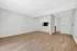 Spacious and modern living area with sleek wooden flooring, clean white walls, and open concept design, perfect for stylish and comfortable living.