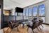 Chic and modern lounge with leather seating, stylish wooden chairs, and large windows offering stunning city views.