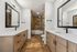 Luxurious modern bathroom with dual sinks, stylish wooden cabinetry, and a sleek glass-enclosed shower.