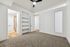 Bright and airy bedroom with plush carpet, built-in shelves, and access to a luxurious en-suite bathroom.