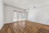 Bright apartment living room with elegant wooden flooring and large windows allowing natural light to fill the space.