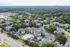 Vibrant aerial view of a charming residential community with multiple apartment buildings surrounded by lush greenery, featuring a central swimming pool and convenient parking.