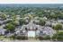 Stunning aerial view of modern apartment community surrounded by lush greenery, featuring a central swimming pool, ample parking, and serene living environment.