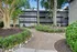 Charming apartment exterior with lush green landscaping, mature trees, and well-maintained pathways creating a tranquil ambiance.