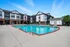 Elegant apartment complex featuring a pristine outdoor swimming pool, surrounded by modern architecture and cozy lounging areas.