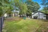 Charming apartment complex with lush greenery, fenced yard, and inviting benches, offering a serene outdoor retreat.