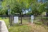 Charming, fenced-in dog park with lush green trees, inviting benches, and clear signage, offering a perfect outdoor space for pets and owners to enjoy.