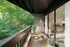 Charming balcony retreat with chic seating overlooking lush green forest, perfect for relaxation and nature views.