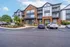 Charming apartment building with modern brick and siding facade, lush landscaping, and convenient parking.