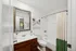 Bright and modern bathroom featuring elegant fixtures, wood vanity, and stylish decor.