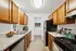 Modern kitchen with elegant wooden cabinets, sleek stainless steel appliances, and a stylish stone countertop, creating a warm and inviting culinary space.