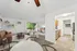 Bright and airy open-concept living area with modern decor, featuring a cozy brown sofa, stylish coffee table, and sleek kitchen with stainless steel appliances.