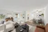 Inviting living and dining area with modern decor, lush greenery, and ample natural light.