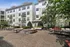 Charming apartment courtyard with stylish outdoor seating, lush greenery, and modern architecture.