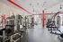 Modern fitness center featuring state-of-the-art gym equipment, sleek design with red accents, and abundant natural light.