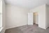 Bright and inviting room with plush carpet and an open closet, ideal for a cozy bedroom or home office setup.