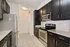Modern kitchen with sleek dark cabinets, stainless steel appliances, and granite countertops.