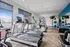 Bright and modern fitness center with state-of-the-art equipment, including treadmills, ellipticals, and a variety of colorful exercise accessories.