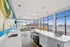 Modern open-concept living area with vibrant decor and expansive city views, featuring stylish furnishings and natural light.