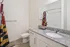 Elegant bathroom with modern granite countertop, sleek white cabinets, and vibrant shower curtain.