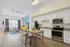 Contemporary open-plan apartment featuring a stylish kitchen with granite countertops and stainless steel appliances, connected to a vibrant living area with a sunny yellow sofa and modern decor.