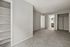 Inviting room with plush carpet flooring, open closet space, and built-in shelving, adjacent to a modern bathroom.