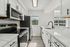 Modern kitchen with sleek stainless steel appliances, elegant white cabinetry, and bright natural light streaming through the window.
