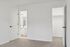 Bright bedroom with plush carpeting, leading to a modern bathroom and spacious walk-in closet.